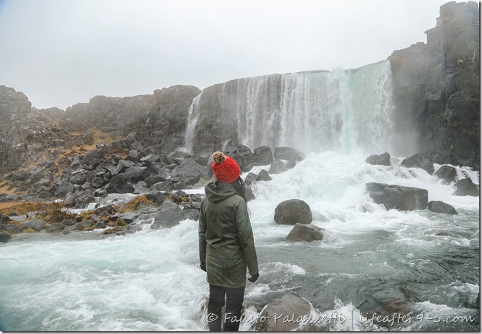 Woman standing in front of Öxarárfoss in Thingvellir