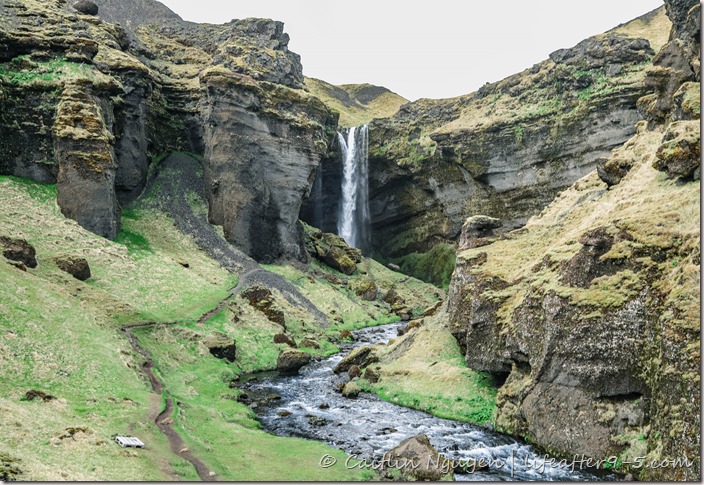 Hidden waterfall Kvernufoss surrounded by lush landscape