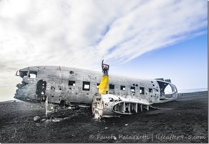 Woman posing on top of Sólheimasandur plane wreck