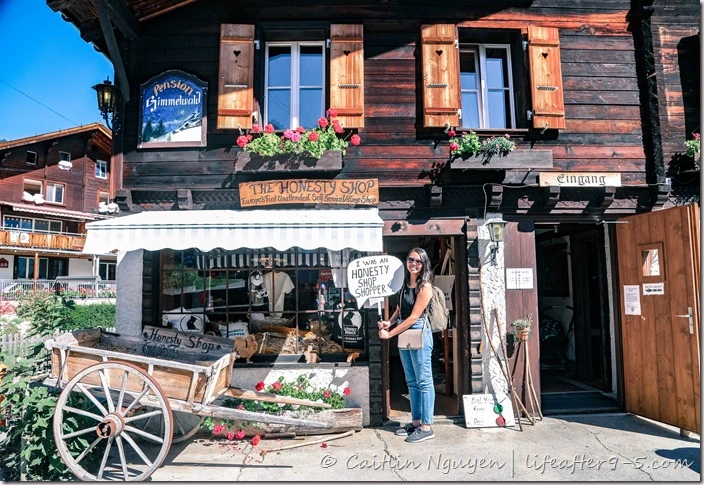 Woman standing in front of honesty shop in Gimmelwald